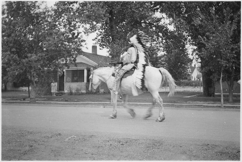 File:Indian in native dress rides horse past homes - NARA - 285236.jpg