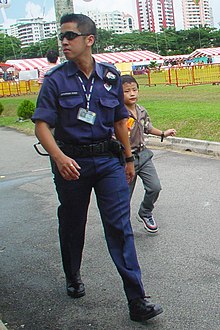 Police Coast Guard officer at the Police Week Carnival 2002, donning the old PCG uniform which was phased out in mid-2006 Police Coast Guard Officer 01.jpg