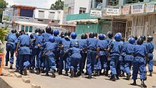 Burundian riot police in action in April 2015 against anti-government protestors during the popular unrest in 2015-2018 Policiers burundais pourchassent des manifestants qui protestent contre un 3e mandat du president Pierre Nkurunziza, vendredi 17 avril 2015.jpg