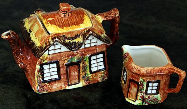 A mass-produced teapot and milk jug set, themed like an old cottage