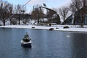 Ruderboot mit Tannenbaum im Olympiasee vor Olympiaschwimmhalle München