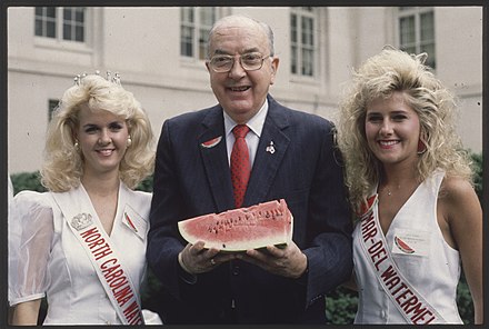 Senator Helms holding a watermelon and standing between Miss North Carolina and Miss Watermelon in 1991
