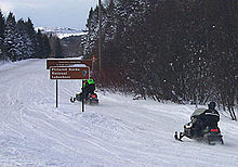 Photograph showing snowmobiles using a snow-covered H-58