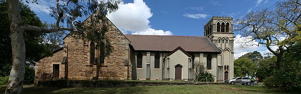 The northern side of the church building. The central rendered section (nave) is the original church building. The sandstone section on the left (tran