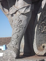 Gros plan sur les jambes du prophète Osée, où l'on peut voir de nombreuses cavités creusées par des vandales.