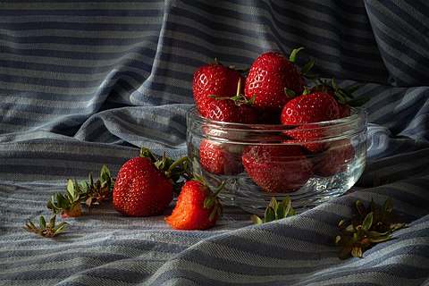 Still life with strawberries in a crystal bowl.