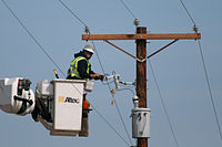 A utility electrician/lineperson does maintenance on a utility pole. Utility worker 4460.jpg