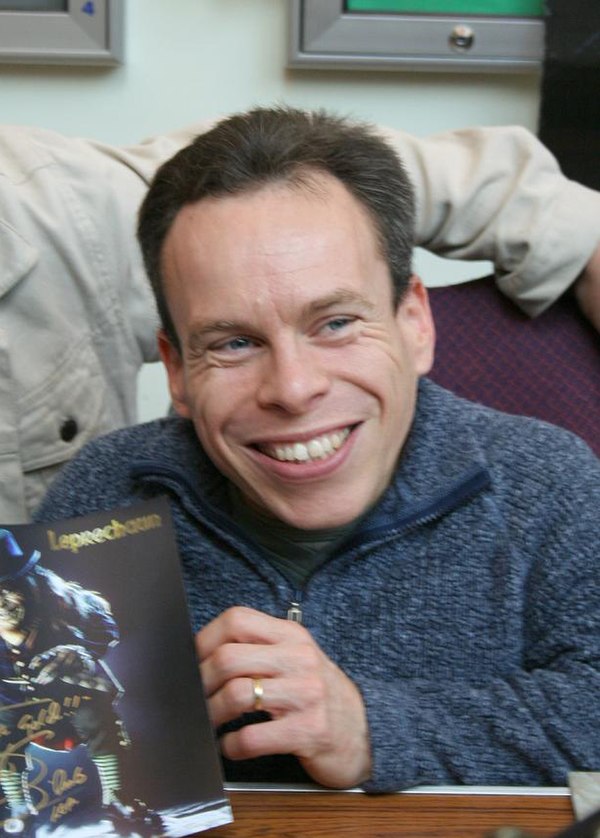 Warwick Davis signs Leprechaun merchandise at the Norwich Sci-Fi Film, Toy, and Collectors' Fair in 2006.