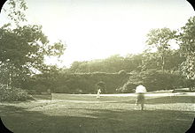 Two people play tennis in Franklin Park, 1906.