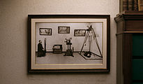 תצלום רפרודוקציה של תצוגת עבודת משטרת פריז שהוכנה עבור היריד העולמי של 1889, המציגה את שיטת "ברטיונז'" של אלפונס ברטיון. משמאל, תצלום זהות סטנדרטי של אסיר, מימין, מצלמה לצילום זירות רצח, ומאחור, תיק לעריכת מדידות אנתרופומטריות. צולם במוזיאון של משטרת פריז, בחדר המוקדש לברטיון