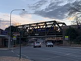 Železniční most Argyle Street, Moss Vale. Fotografie pořízená na rohu ulice Arthur a Argyle. V okamžiku, kdy byla pořízena tato fotografie, projíždí most most.