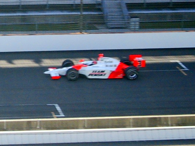 Hélio Castroneves makes his pole-winning qualification run in 2007 during "Happy Hour". Note the shadows cast on the racing surface.