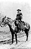 An image of Daniel Brottier in a long black cassock, seated horseback as a chaplain in World War One.