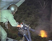 A U.S. Air Force rotary-wing crewman fires a minigun during the Vietnam War.