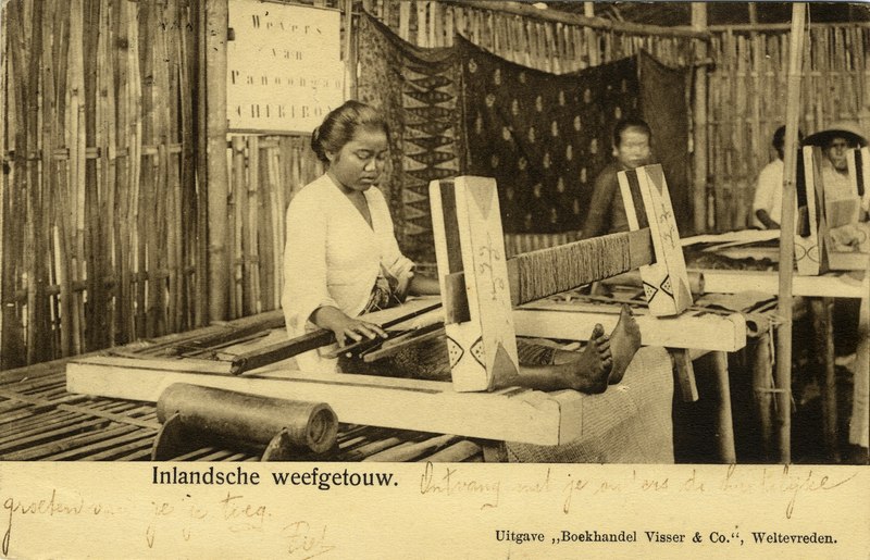 Inlandsche weefgetouw . Foto vermoedelijk genomen op een tentoonstelling, gezien het opschrift op het bord Weevers van .. Cheribon, KITLV 1401158