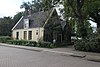 Houten huis met zadeldak, evenwijdig aan de straat