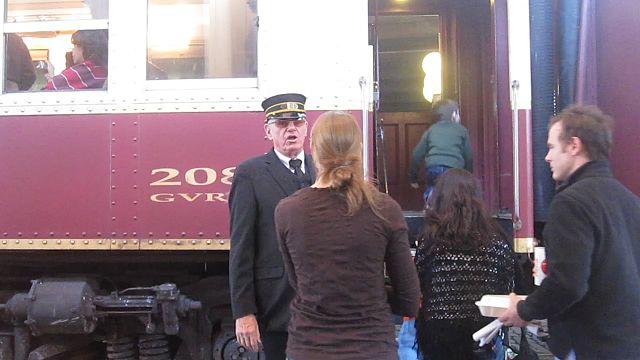 The conductor assists a passenger as the Grapevine Vintage Railroad stops at the Fort Worth Stockyards.