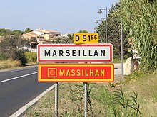 Ortsschild für Marseillan auf Französisch und Okzitanisch. Das okzitanische Wappen und die Farben (rot und gold) erscheinen auf dem Zeichen.