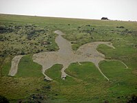 Figure of a prancing white horse cut into the hillside with a rider. Osmington White Horse near Weymouth, Dorset