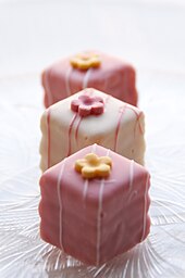 Small, square cakes frosted with pink or white icing