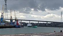 A view of the Port of Ipswich, showing a medium sized cargo vessel entering port under the Orwell Bridge.