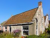 Woning (Reddingsboatreed 8) met zesruitsvensters onder zadeldak tussen gepleisterde topgevels