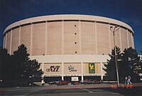 Exterior of a large cylindrical building, with the logo of the Salt Lake Golden Eagles visible on its front