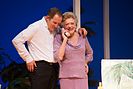 Nancye Hayes (holding a phone) and Todd McKenney (arm over her shoulder, listening) during a performance of the play Six Dance Lessons in Six Weeks