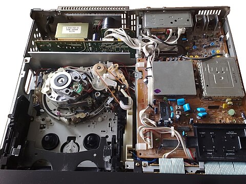 Parts in the interior of the Betamax VCR (top). Main components, such as heavy-duty power source, tape mechanism and its parts (lower left), main circuit boards (right), and TV tuner buttons revealed (lower right).