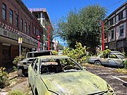 Film set of broken cars with growing foliage