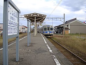 Farbfoto eines Zuges, der an einem Bahnhof ankommt