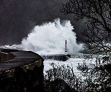 Eine Welle, die gegen eine felsige Böschung prallt