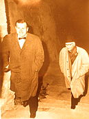 Dwóch mężczyzn w garniturach wchodzi po schodach.  Jeden z nich z muszką.