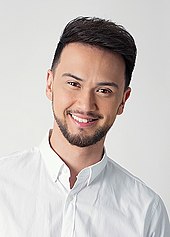 A headshot of Billy Crawford smiling at the camera