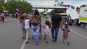 A man, a woman and five children walking, seen from behind