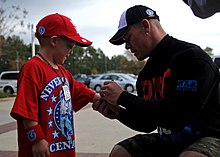 Cena signing merchandise for a young fan