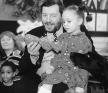 Blunkett's guide dog Lucy receiving a gift at a nursery school, 1999 David Blunkett at Margaret McMillan Nursery School.png