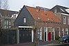 Woonhuis, onderdeel van een klein bouwblokje met twee woningen in traditionele vormen, in oorsprong 17de-eeuws, wellicht uit 1664, verbouwd in het begin van de 19de eeuw. Tussen de woningen een als rijksmonument beschermd poortje uit 1664.