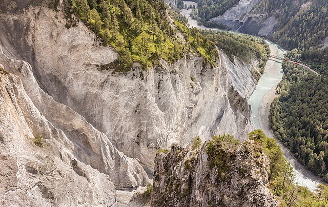 Вид на ущелье Ruinaulta[англ.] массива Flims rockslide[англ.] со смотровой площадки Иль Спир[англ.]. Виден мост Ретийской железной дороги через Передний Рейн. Коммуна Флимс, кантон Граубюнден, Швейцария