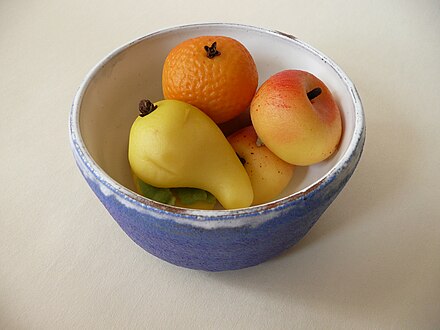 A bowl containing several fruit-shaped marzipan pieces