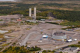 Flygbild över gruvområdet i Tuolluvaara med Kirunas nya centrum och stadshus i förgrunden och gruvlavarna i bakgrunden.