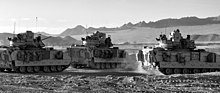 Three M2A3 Bradleys exit an OCCD at the start of a Patrol at Fort Irwin, California. M2A3 Bradley's Prepare for Patrol.jpg