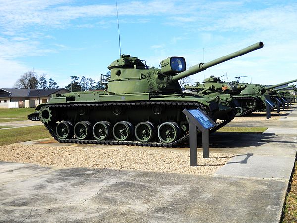 An M60 tank with an infrared searchlight mounted on the cannon.