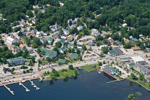 An aerial view of the intersection of Daniel Webster Highway (US 3) and Main Street in Meredith, New Hampshire. North is to the right. NH 25 enters fr