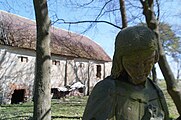 Zámek Meziříčí, socha v zámecké zahradě (Panna Marie?) s hospodářskou budovou v pozadí