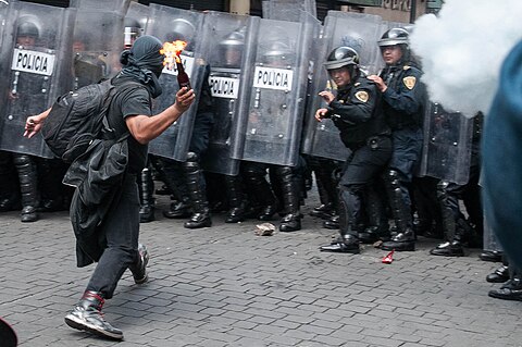 An anarchist protester with a Molotov cocktail aimed at police during protests in 2013 in Mexico.