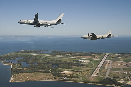 A P-8A Poseidon flies formation with a P-3C Orion overhead Naval Air Station Patuxent River, Maryland, 2010 P 8 and P 3 over Pax River.jpg