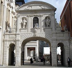Temple Bar (1672) di Christopher Wren, in origine su Fleet Street ora su Paternoster Square. Si tratta dell'ultima sopravvissuta porta di Londra.