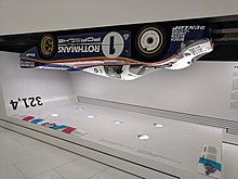 A Porsche 956 mounted upside down in a museum exhibit.