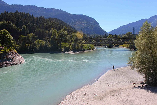 The confluence of the Anterior Rhine to the lower left and the Posterior Rhine in the background forms the Alpine Rhine (to the left) next to Reichena